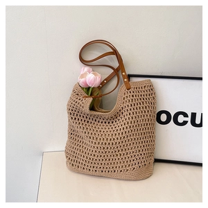 Close-up of beige crochet tote bag with honeycomb texture and brown leather straps