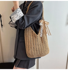 Détail du sac cabas en paille ajourée avec un charme délicat en ruban de soie et dentelle