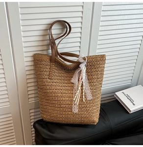 Detailed texture of natural woven straw tote with elegant white lace ribbon and leather strap