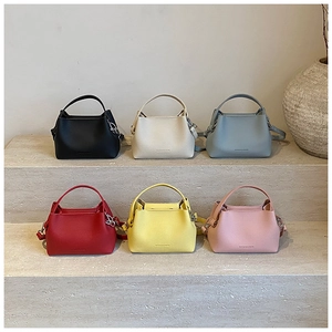 Sacs seau minimalistes en plusieurs couleurs disposés sur des marches sobres