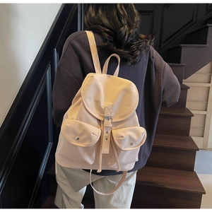 Detail of college style backpack with drawstring closure and metal buckles on steps