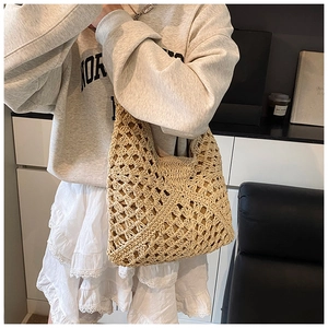 Detailed macro view of the intricate diamond crochet weave pattern on a beige straw tote bag