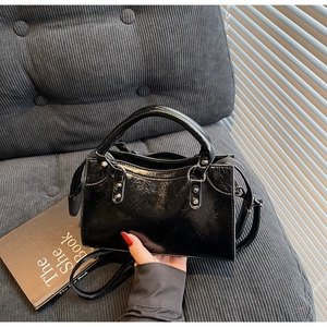 Détail de sac à main en cuir verni noir brillant avec des rivets métalliques argentés
