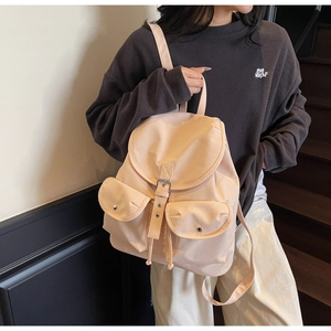 Fashionable beige backpack featuring silver buckle pockets and drawstring closure detail