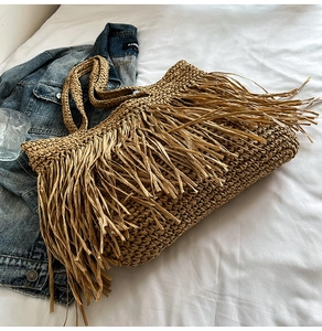 Detailed close-up of bohemian large capacity straw tote bag with elegant fringe tassels