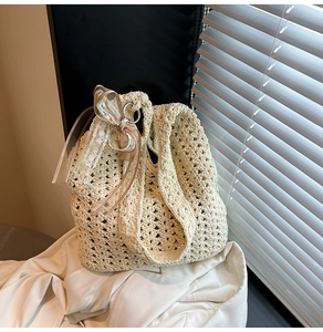 Détail d'un sac cabas tissé ajouré avec un nœud en dentelle délicat en blanc crème