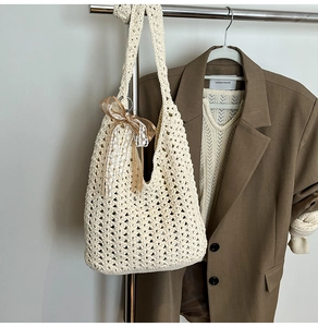 Détail du sac cabas tissé ajouré avec un nœud en dentelle beige et texture crochet