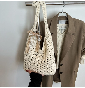 Détail d'un sac cabas au crochet avec motifs ajourés et breloque en ruban de soie