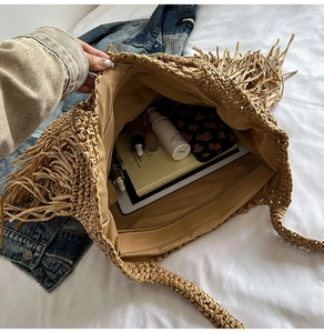 Macro view of large straw tote bag interior showing spacious storage for daily items
