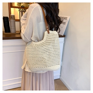 Close-up of beige crochet tote bag featuring handcrafted mesh weave and brown leather strap