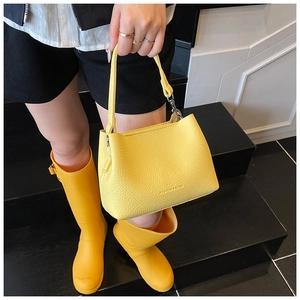 Détail du sac seau en cuir jaune vif avec poignée supérieure et lettrage Fashion & Bags