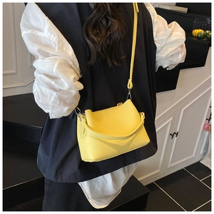 Détail du sac seau jaune en cuir avec poignée estampillée fashion et bandoulière