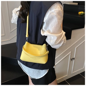 Détail d'un sac seau jaune vif avec design oreilles de chat et bandoulière réglable