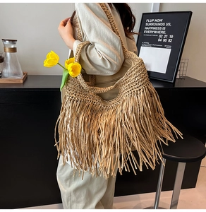 Detail of bohemian straw shoulder bag featuring textured fringe and woven beach style
