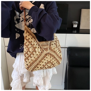 Detail of a handmade straw tote bag showing a unique woven pattern and hobo style shape