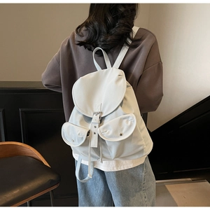 Detail of minimalist cream white nylon backpack showing straps and back view on a model