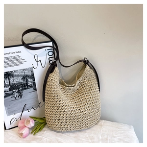 Detail of hand-woven straw hobo bag texture with premium brown leather strap