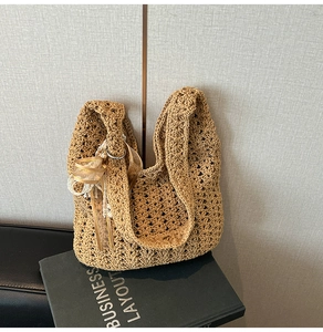 Détail de la maille crochetée à la main avec un nœud papillon doré sur le sac fourre-tout