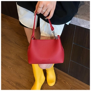 Détail d'un sac seau en cuir grainé rouge avec lettrage argenté Fashion & Bags
