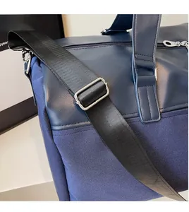 Detail of adjustable wide nylon shoulder strap with silver metal buckle on a navy travel bag