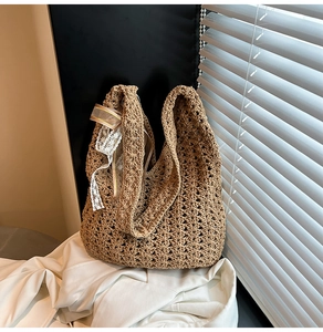 Détail du sac cabas tressé marron avec bordure en dentelle et nœud en ruban chic