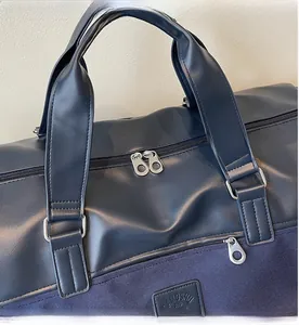 Detail of high-quality silver zipper and PU leather stitching on navy blue travel bag