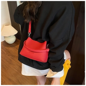 Détail du sac seau rouge à motif litchi avec texte Fashion & Bags et fermoir argent