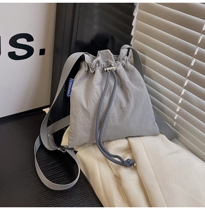 Detailed macro view of gray nylon bucket bag with drawstring closure and texture