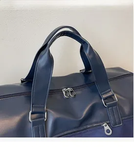 Detail of durable double handles and silver zipper on the dark blue travel bag