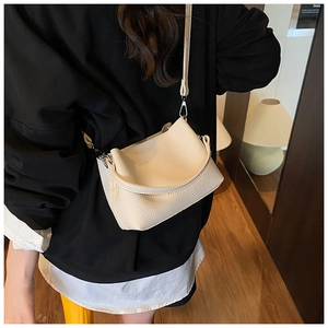 Vue détaillée du sac seau blanc crème avec texture cuir grainé et boucles argentées