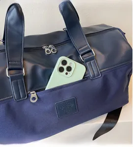 Detail of navy blue travel bag showing dual-material texture and front zipper pocket