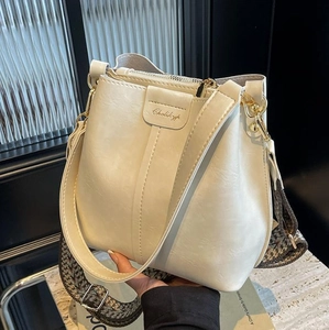 Bolso cubo blanco crema con textura de lichi y elegante correa tejida en blanco y negro