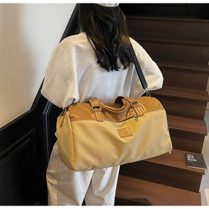 Detail of canvas travel bag with leather handles and wide adjustable shoulder strap