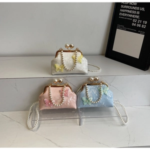 Détail de broderies et appliqués papillon 3D sur d'élégants sacs à main en perles de luxe