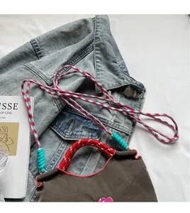 Detail of colorful woven rope handles and vibrant braided straps on casual bag