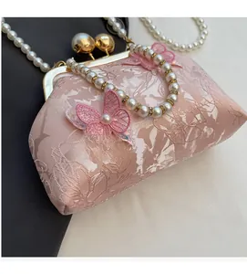Détail du sac satin rose avec jacquard floral et broderie papillon 3D ornée de perles