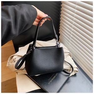 Détail du sac seau noir en cuir grainé avec inscription FASHION & BAGS embossée