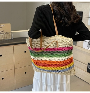 Detailed back view of a rainbow striped woven straw tote bag with brown leather handles