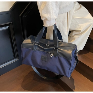 Detail of a large navy canvas travel tote with leather handles on a staircase