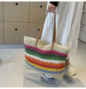 Close-up of vibrant rainbow woven tote bag featuring durable brown leather handles