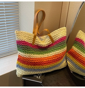 Detail of colorful rainbow woven straw tote bag with brown synthetic leather handles