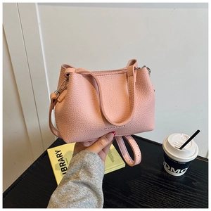 Détail du sac seau rose texture litchi avec poignée solide et boucle métallique
