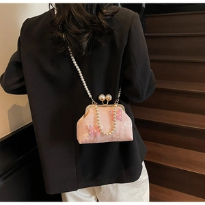 Vue détaillée du sac coquillage rose brodé avec papillon et bandoulière perles