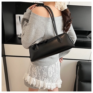 Minimalist black glossy leather baguette bag with thin dual shoulder straps detail