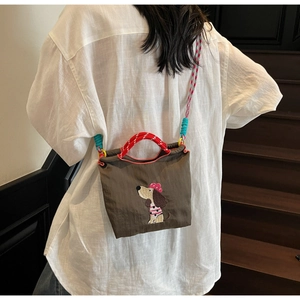 Detail of dachshund embroidery on dark brown nylon bag with colorful braided straps