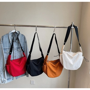 Canvas crescent bags in four colors with adjustable straps and zipper closure detail