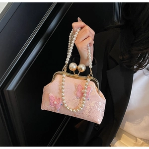 Détail d'un sac en soie rose avec broderie florale et papillons en paillettes 3D