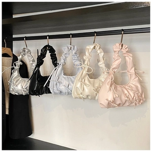 Détails des bandoulières plissées et des nœuds décoratifs sur les sacs à main pastel