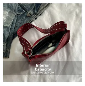 Detailed interior of a red studded shoulder bag showing storage for cosmetics