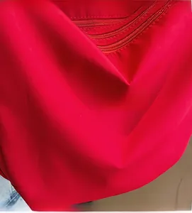 Detail view of the red canvas hobo bag showing lightweight fabric and dual zipper closures
